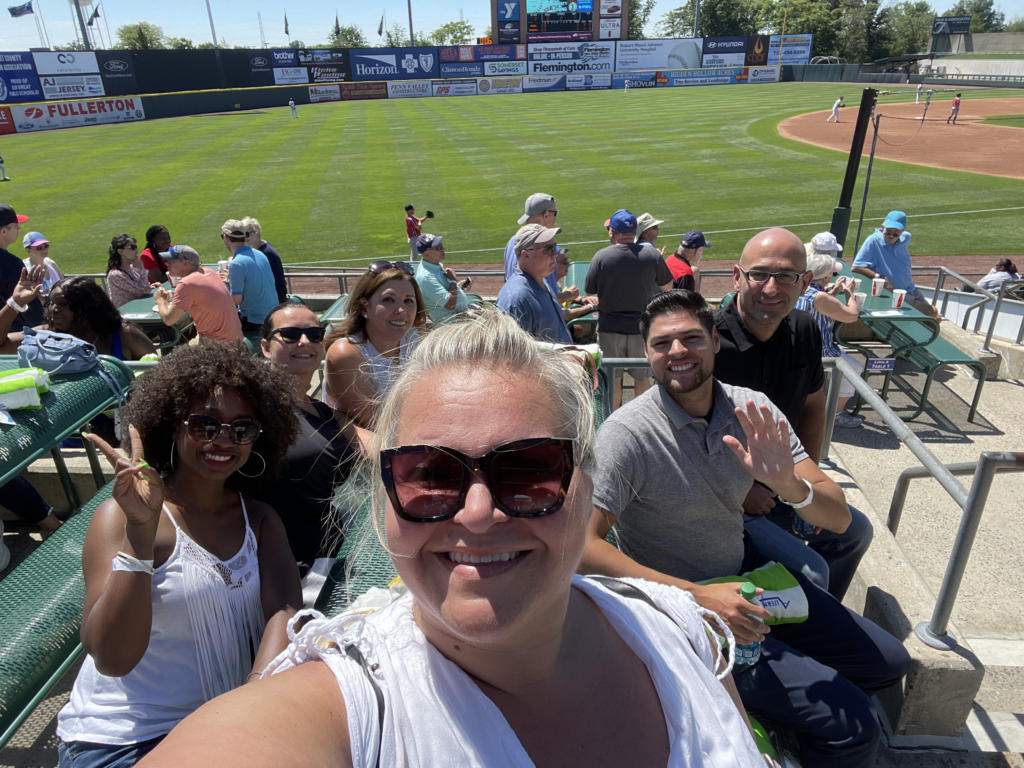 Smiling group attending a minor league baseball game. Alternatives Inc.