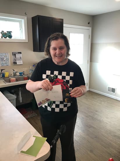 Woman smiling in a group home kitchen. Alternatives Inc